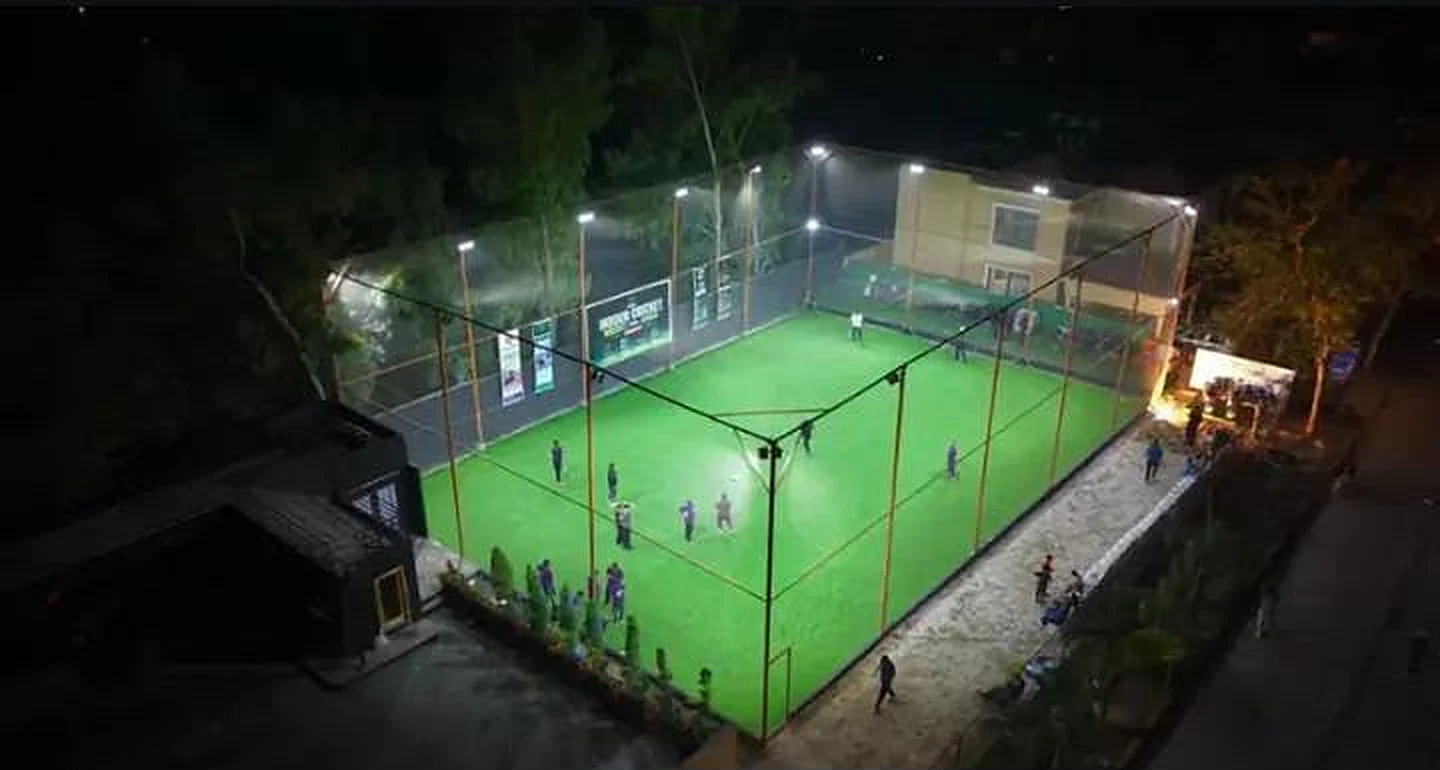 Aerial view of a floodlit football turf ground enclosed by KHS Sports Nets netting at night